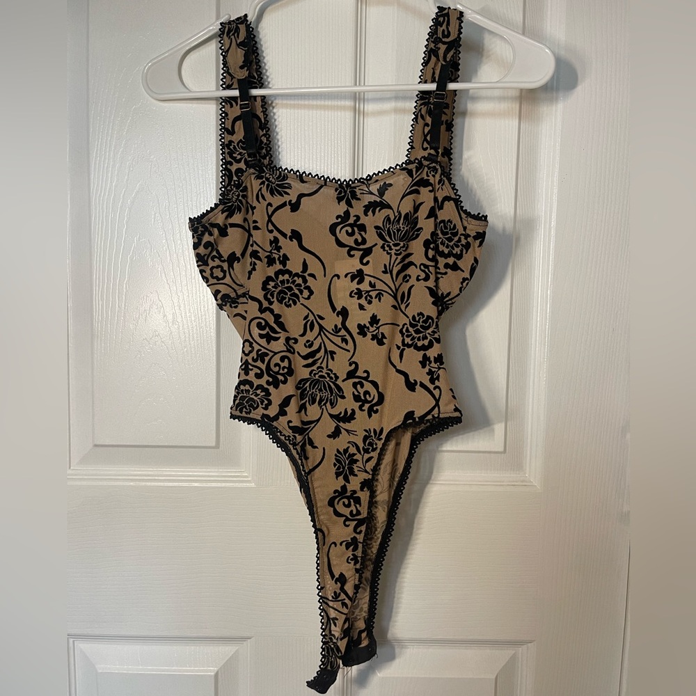 Tan corset body suit with black design and sheer fabric